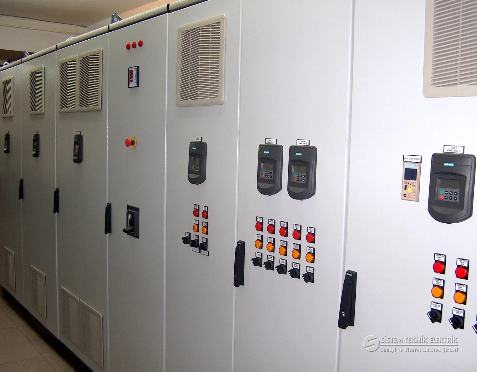Pano İmalatı ve Elektrik Projelendirme — Uzun pano dizisi, sürücü göstergeleri, eğik perspektif.